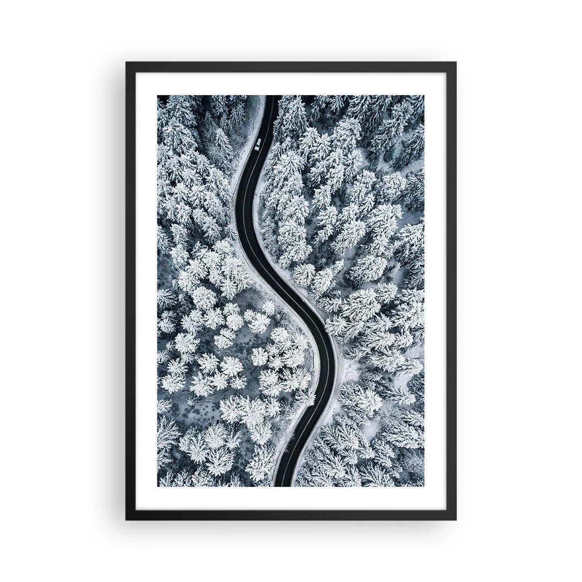 Poster in black frame - A picturesque road among snow-covered trees from a bird's eye view - 50x70cm - Through Wintery Forest - Modern wall decoration for the living room and bedroom ARTTOR